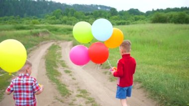 Mutlu çocuk bir orman yolu balonlar ile çalıştırın. Parkta Doğum günü kutlaması. Kahkaha ve çocuk sevinci