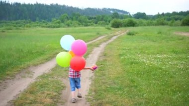 Mutlu küçük bebek, balonlarla koşturup eğlenceli. Açık rekreasyon. Kutlama ve eğlence. Childs'ın Doğum günü