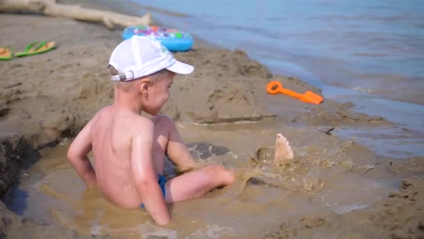Kind spielt mit Sand am Strand. Sommer sonniger Tag, gute Laune. — Stockvideo