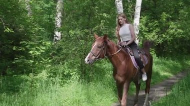 Parkta binme. Bir at binme kız parkta yürüyüş yapsın