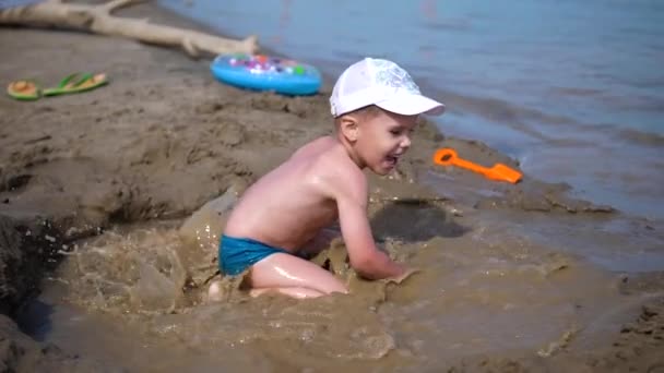 Niño jugando con arena en la playa. Verano Día soleado, buen humor . — Vídeos de Stock