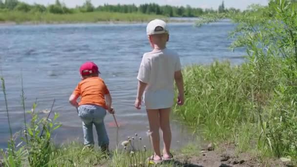 Två barn fånga fisk vid floden Bank. Vackra sommarlandskap. Friluftsliv och rekreation. — Stockvideo
