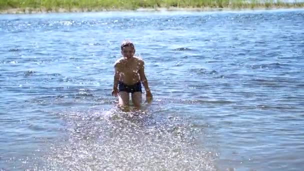 幸せな男は山の川で泳いでいます。水スプレー、熱い夏の日 — ストック動画