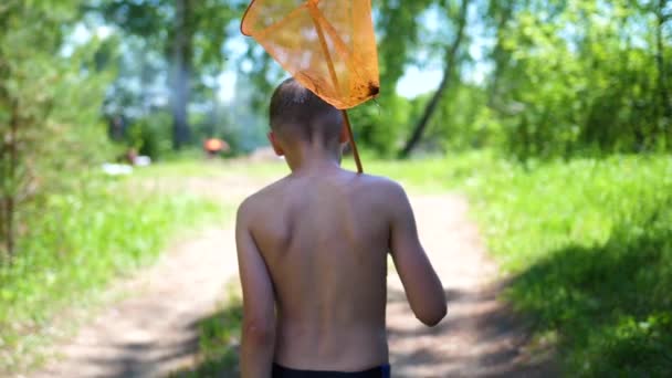 钓鱼后的那个人在一条森林路上。掌握在手中的网。炎热的夏日。暑假在村庄里. — 图库视频影像