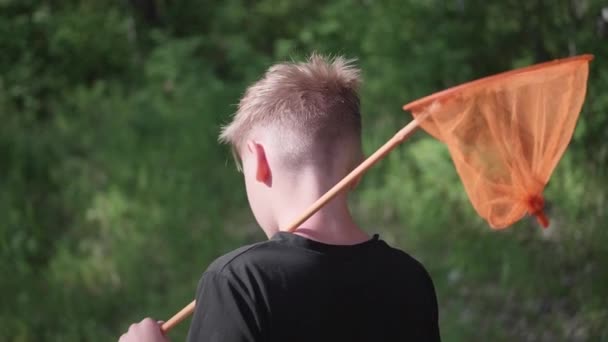 Le gars après la pêche est sur une route forestière. Dans les mains de tient net. Une chaude journée d'été. Vacances d'été dans le village . — Video