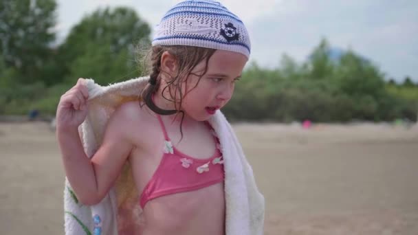 Девушка на пляже вытирает тело полотенцем после купания. Летние каникулы, отдых у моря . — стоковое видео