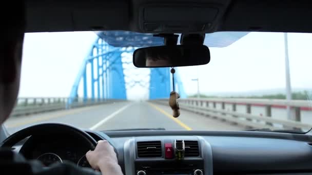 Családi utazás autóval. Van egy kis eső, az autó halad át a hídon a folyó felett — Stock videók