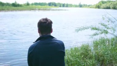 Balıkçı bir olta ile nehir banka olduğunu. Güzel yaz manzara. Açık rekreasyon. Hobi