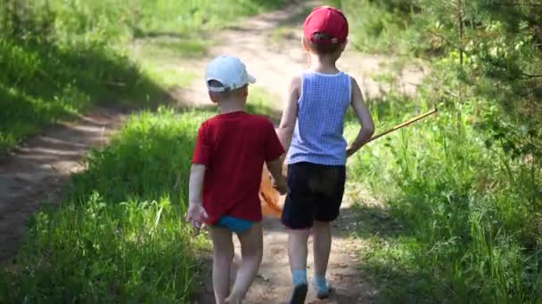 Dvě děti ulovených ryb. Chlapci jsou na lesní cestě s catch. Krásné letní krajina. Venkovní rekreace. — Stock video