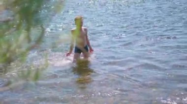 Mutlu erkek dağ nehirde yüzüyor. Sprey, sıcak yaz günü su