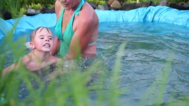 Aile bir sıcak yaz gününde küçük gölde yüzüyor. Büyükanne küçük bir çocuk yüzmeyi öğrenir. Bahçe, çiçek ve bitki göl çevresinde.