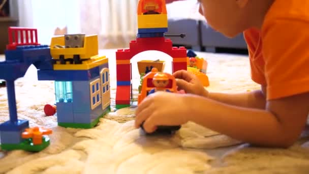 Los niños juegan con juguetes.Los niños en la sala de juegos que juegan con el conjunto de construcción recogen artículos de cubos pequeños y partes — Vídeo de stock