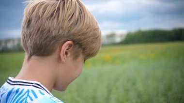 mesafe içine bakan bir genç adam bir buğday field.the genç adam uzakta buğday alan yapar. fırtına bulutları geliyor