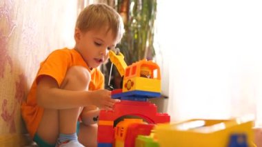 Çocuklar oyuncaklarla oynamak. İnşaat set ile oynarken oyun salonu çocuklarda küçük küpler ve bölümleri öğeleri toplamak. çocuk demiryolu