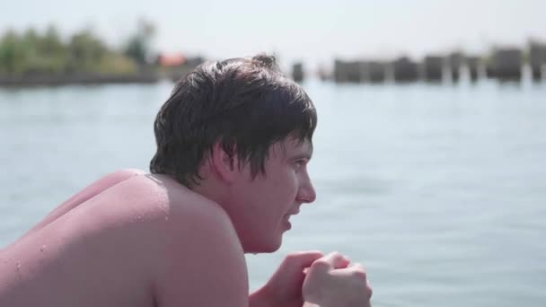 Ein junger Mann schwimmt auf einer aufblasbaren Matratze im Meer. positive Emotionen. Heißer Sommertag — Stockvideo