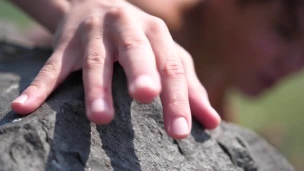 El escalador sube a las rocas. El logro de la altura, un deporte extremo. Mano de cerca . — Vídeo de stock