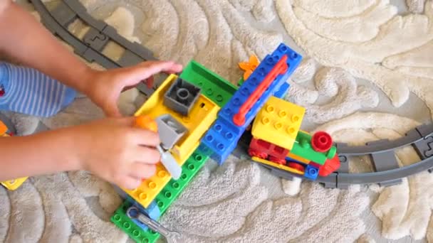 Çocuklar oyuncaklarla oynamak. İnşaat set ile oynarken oyun salonu çocuklarda küçük küpler ve bölümleri öğeleri toplamak. çocuk demiryolu — Stok video