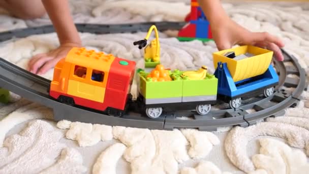 Çocuk oyuncaklarla oynar. Çocuklar bir bina set ile oynarken oyun odasında küçük küpler ve yerlerinden öğeleri toplar. Çocuk demiryolu — Stok video