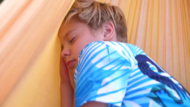 Chlapec spí v houpací síti venku. Venkovní rekreace — Stock video