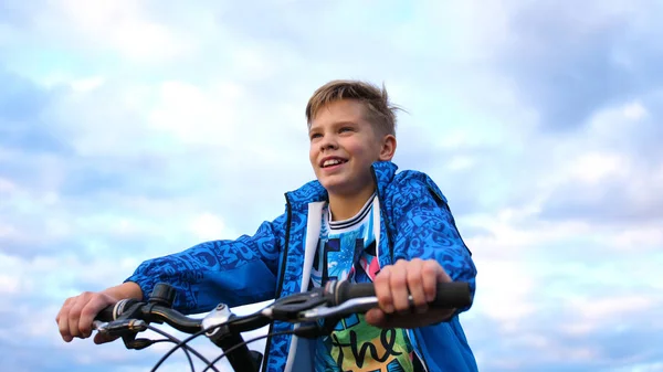 Remaja mengendarai sepeda, melakukan olahraga di udara segar. Perjalanan dan hiburan aktif. Saat-saat masa kecil yang bahagia Stok Foto Bebas Royalti