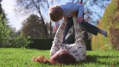 Mutlu bir aile. Anne oğlunu kucağında çocuk gülümsüyor tutar. Güneş ve gökyüzü mutlu Childs'ın yüz arka plan üzerinde