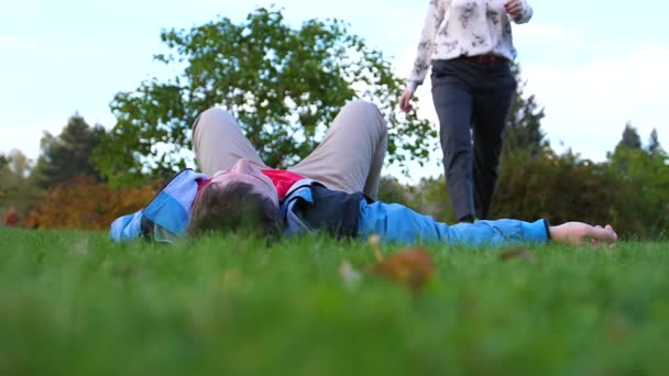 Une jeune fille et un mec allongés sur la pelouse . — Video