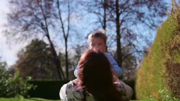 Lycklig familj vilar på gräsmattan. Mor med ömhet och kärlek spelar med sitt barn, sonen skrattar, han har kul. Lycklig barndom — Stockvideo