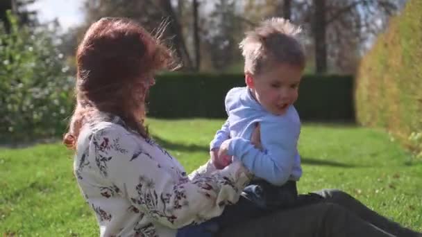 행복 한 가족 잔디밭에 쉬고입니다. 부드러움과 사랑으로 어머니 그녀의 아이와 아들 웃음 연극, 그는 재미 있다. 행복 한 유년 시절 — 비디오