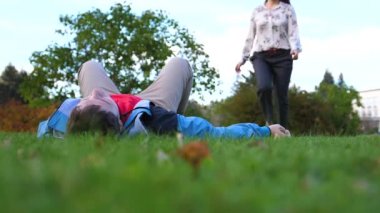 Genç bir kız ve bir adam çim üzerinde yalan.