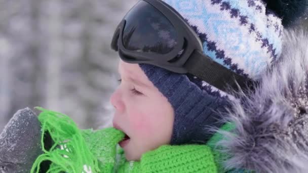 Мальчик в зимнем парке, лицо крупным планом. Зимний мороз. Гулять на свежем воздухе. Здоровый образ жизни — стоковое видео