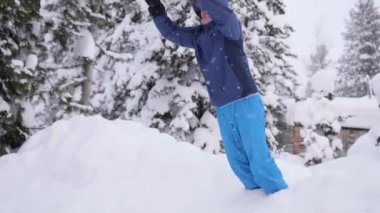 Adam ağır çekimde kar içine atlar. Etkin açık spor. Kış güneşli gün