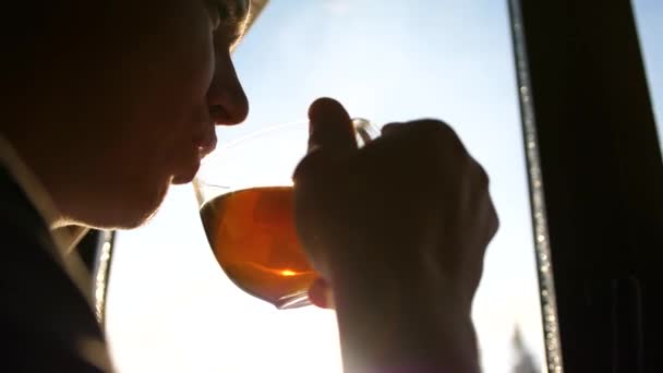 Día helado de invierno. El tipo temprano en la mañana de pie en la ventana y beber té caliente . — Vídeos de Stock