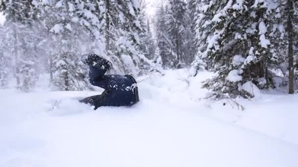 孩子在缓慢的运动中坠入雪中。户外活动的运动。冬晴日 — 图库视频影像