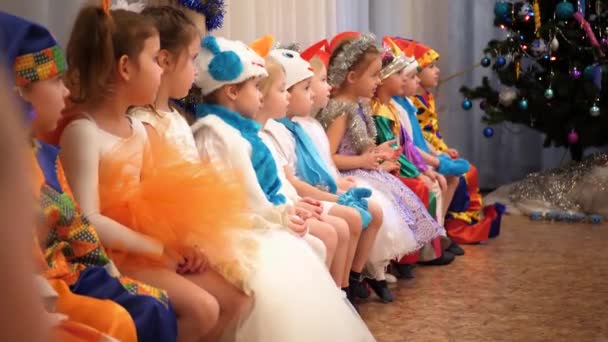 俄罗斯新西比尔斯克-2018年1月1日: 儿童狂欢节。年幼的孩子们穿着狂欢节的服装。他们坐着看节日的演出 — 图库视频影像