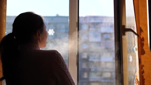 Chladný zimní den. Dívka se otevře okno a dýchá v ledovém vzduchu. — Stock video
