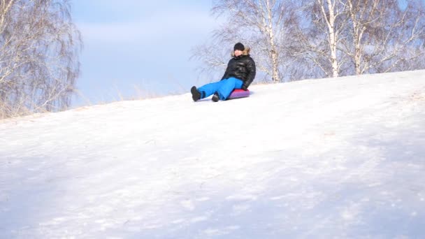 Un tipo montando una montaña nevada. En cámara lenta. Paisaje invernal nevado. Deportes al aire libre — Vídeo de stock