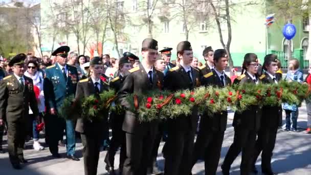 NOVOSIBIRSK, RUSSIA - 9 Mei 2019: Laki-laki dan perempuan muda berbaris. Mereka membawa karangan bunga untuk diletakkan di monumen — Stok Video