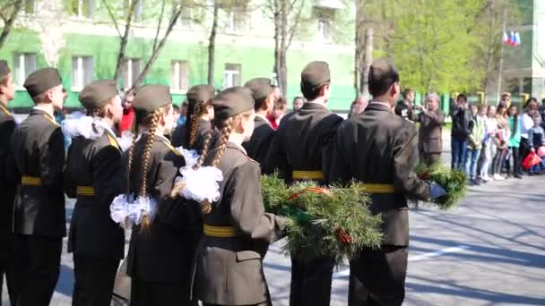 Nowosybirsk, Rosja-9 maja 2019: Młodzi chłopcy i dziewczęta marszu. Nosili wieniec leżał na pomniku — Wideo stockowe