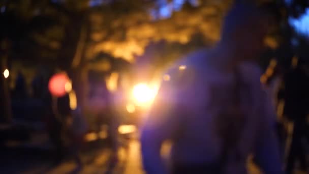 People walk in the evening in the Park on the waterfront. Bright lights, blur — Stock Video