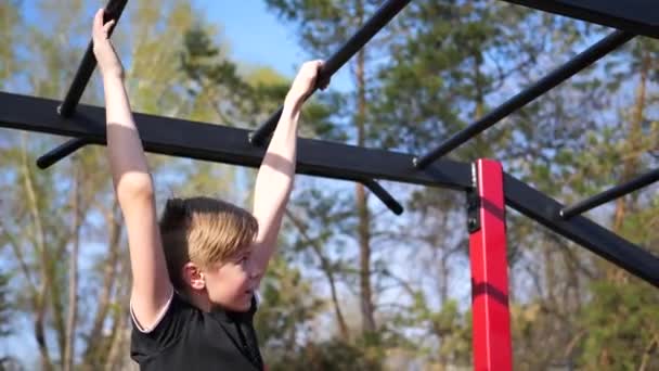 Exercice à l'air frais. Jeune homme fort faisant des exercices sur le bar. Parc d'automne — Video