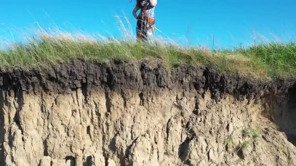 La chica está en el borde del acantilado. Hermoso paisaje de montaña río y bosque. Disparos desde arriba — Vídeo de stock