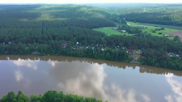 Overzicht van het prachtige zomer landschap. UAV-vlucht over de rivier en het dorp. Vogels-Eye View — Stockvideo