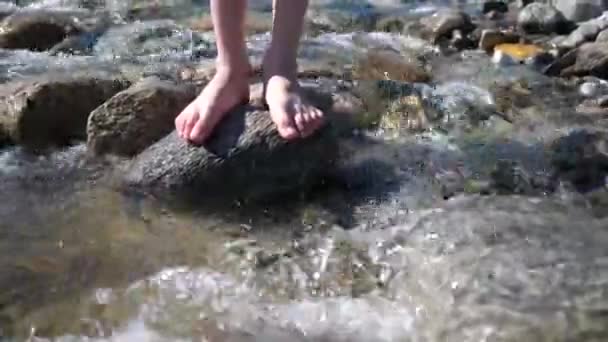 Dağ nehri. Adam bir kaya üzerinde duruyor, su ayakları ve taş etrafında akar. Sabah erkenden gezgin. — Stok video