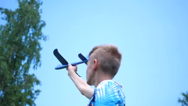 Парень держит в руках самолет равнины, имитирует полет — стоковое видео