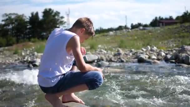 Le gars se lave l'eau froide de montagne. Tôt le matin voyageur . — Video