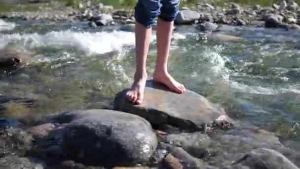 山の川男は岩の上に立って、水は彼の足と石の周りに流れます.早朝旅行者. — ストック動画