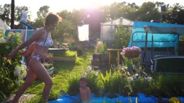Sıcak bir yaz gününde bir kadın küçük bir gölde yüzüyordu. Suya atlıyor, su sıçraması yapıyor. Bahçe, çiçekler ve gölün etrafında bitkiler. İyi Bayramlar