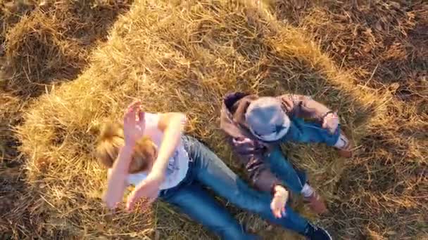 Çocuk samanlıkta duruyor ve ellerini sallıyor. Oynuyor ve gülüyor. Gün batımı — Stok video