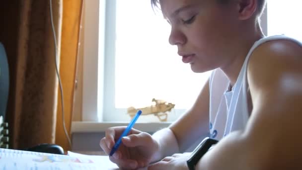 Der Schüler schaut sich die Lektion online an und lernt zu Hause. Ein junger Mann erledigt seine Hausaufgaben, während er zu Hause ist. Schulbildung. — Stockvideo