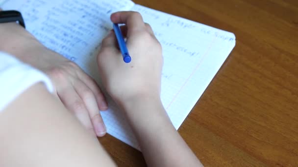 Egy fiatal srác megcsinálja a házi feladatát, amíg otthon van. Iskolai oktatás. — Stock videók